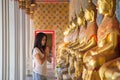 Asian woman in a white t-shirt to pay respect to Buddha statue in the Buddhist temple while traveling in Thailand Royalty Free Stock Photo