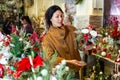 Asian woman chooses a Christmas composition with candles