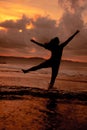 an Asian woman who is playing and dancing on the beach with strong waves Royalty Free Stock Photo