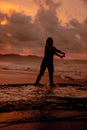 an Asian woman who is playing and dancing on the beach with strong waves Royalty Free Stock Photo