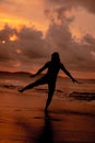 an Asian woman who is playing and dancing on the beach with strong waves Royalty Free Stock Photo