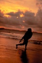 an Asian woman who is playing and dancing on the beach with strong waves Royalty Free Stock Photo