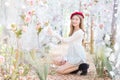 Asian woman who wears white shirt and red cap stands in red-orange leave as forrest in autumn Royalty Free Stock Photo