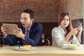 Asian woman who is a wife is suspiciously looking at her husband at restaurant in the morning because she thinks that her husband