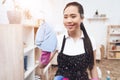 Asian woman wipes glass with a rag and spray.