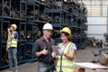 Two happy smiling Asian industrial engineer men with safety vest and helmet fist bumping hand after complete work at manufacturing Royalty Free Stock Photo