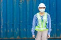 Asian woman worker wearing disposal face mask for protect dust smoke and corona virus while working in shipping logistic workplace