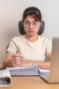 Asian woman working with computer laptop, female businesswoman reading report and sign contract with documents folder stack at