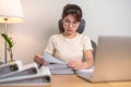 Asian woman working with computer laptop, female businesswoman reading report and sign contract with documents folder stack at