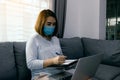 Asian woman working from home at a laptop computer during a coronavirus epidemic by quarantine and wearing medical masks Royalty Free Stock Photo