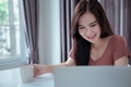 Asian woman video conference user interface with laptop computer remotely working from home Royalty Free Stock Photo