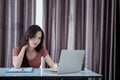Asian woman working from home office overworked stressed deadline on laptop computer