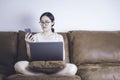 Asian woman working with laptop computer on sofa and checking or looking at her cell phone. Concept work from home, self Royalty Free Stock Photo