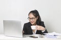 Asian woman working with laptop at white working table, diligent professional working woman drinking coffee while working on lapto Royalty Free Stock Photo