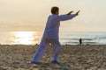 Asian woman working out with Tai Chi in the morning before sunrise at the beach near sea on the city Da nang, Vietnam Royalty Free Stock Photo