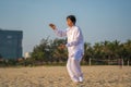 Asian woman working out with Tai Chi in the morning before sunrise at the beach near sea on the city Da nang, Vietnam Royalty Free Stock Photo