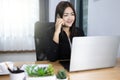 Asian woman working and talking phone in home with laptop computer smile and happy work. Work from home concept Royalty Free Stock Photo
