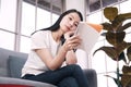 Asian woman is working and writing on notebook. She is thinking and serious for business in sofa at office. Lifestyle of Royalty Free Stock Photo