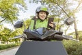 Asian woman works as a motorcycle taxi driver checking order on her mobile phone Royalty Free Stock Photo