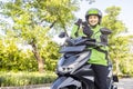 Asian woman works as a motorcycle taxi driver checking order on her mobile phone Royalty Free Stock Photo