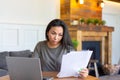 Asian woman works with documents in front of a laptop monitor. She checks the tax records before submitting the report. Royalty Free Stock Photo