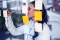 Asian woman writing on sticky notes Royalty Free Stock Photo