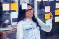 Asian woman writing on sticky notes Royalty Free Stock Photo