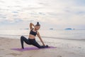 An Asian woman in yoga class club doing exercise and yoga at natural beach and sea coast outdoor in sport and recreation concept. Royalty Free Stock Photo