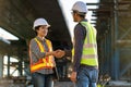 Asian women architect or construction workers in protective helmets and vests are shaking hands with engineer while working at the Royalty Free Stock Photo