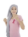 Asian women attach a pink ribbon to their tops. Doing exercise by lifting pink dumbbells on color background. breast cancer