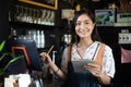 Asian women Barista smiling and using coffee machine in coffee shop counter - Working woman small business owner food and drink