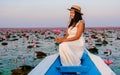 Asian women in a boat at the Red Lotus Sea Kumphawapi full of pink flowers in Udon Thani Thailand. Royalty Free Stock Photo