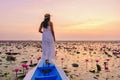 Asian women in a boat at the Red Lotus Sea Kumphawapi full of pink flowers in Udon Thani Thailand. Royalty Free Stock Photo