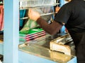 Asian women coating plastic for book make it ready to pack.