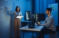asian woman developers collaborating on a coding project, with one member presentation at code projected on the wall while the Royalty Free Stock Photo