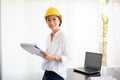 Asian women engineering inspecting and working and holding blueprints at office.she is smiling happy for work Royalty Free Stock Photo