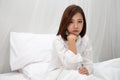 Asian women with feelings of helplessness and hopelessness on white bed in bedroom.