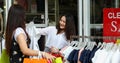 Asian women with friend are holding shopping bags and using a smart phone and smiling while doing shopping in the supermarket/mall Royalty Free Stock Photo