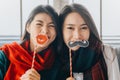 Asian women friends wearing scarf playing with paper props having fun