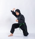 Asian women in headscarves wear pencak silat uniforms with squat green belts while performing defensive movements