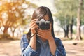 Asian women holding a camera shooting in nature