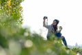 Asian women holding hot tea cup for drinking and take a photo in the morning day, relaxing and sitting outdoor in the tea plantati Royalty Free Stock Photo