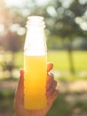 Asian women holding orange juice bottle.