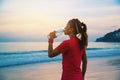 Asian women jogging workout on the beach in the morning. Relax with the sea walk and drinking water from the plastic bottles Royalty Free Stock Photo