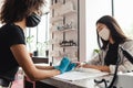 Manicure master in protective medical mask in beauty salon. African american girl in gloves doing nail procedure