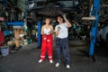 Asian woman mechanic help her co-worker man to fix the problem of car in area under the car and the work in workplace of garage