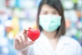 Asian women medical doctor holding a red heart ball with blurred background. Concept of health care Royalty Free Stock Photo