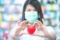 Asian women medical doctor holding a red heart ball with blurred background. Concept of health care Royalty Free Stock Photo