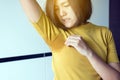 Asian women with odor sweating,Female smelling or sniffing her armpit,Bad smell,Copy space for text and white background Royalty Free Stock Photo