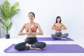 Asian woman practicing yoga indoor with easy and simple position to control breathing in and out in meditation pose